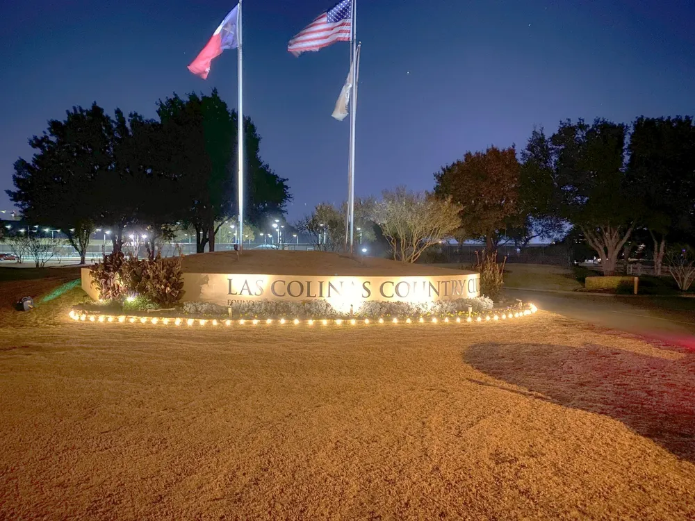 A lit country club entrance monument at night in the DFW metro