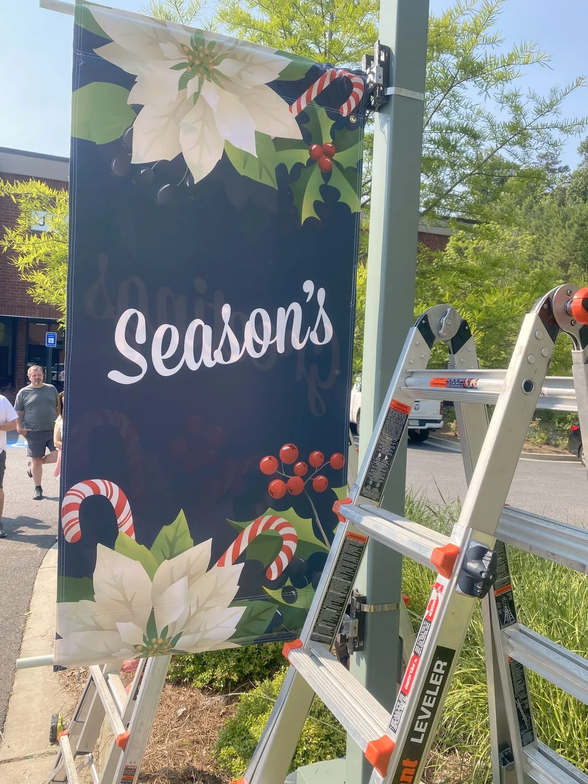 Installing seasonal pole banners downtown, installed by South Custom Lighting in North Texas