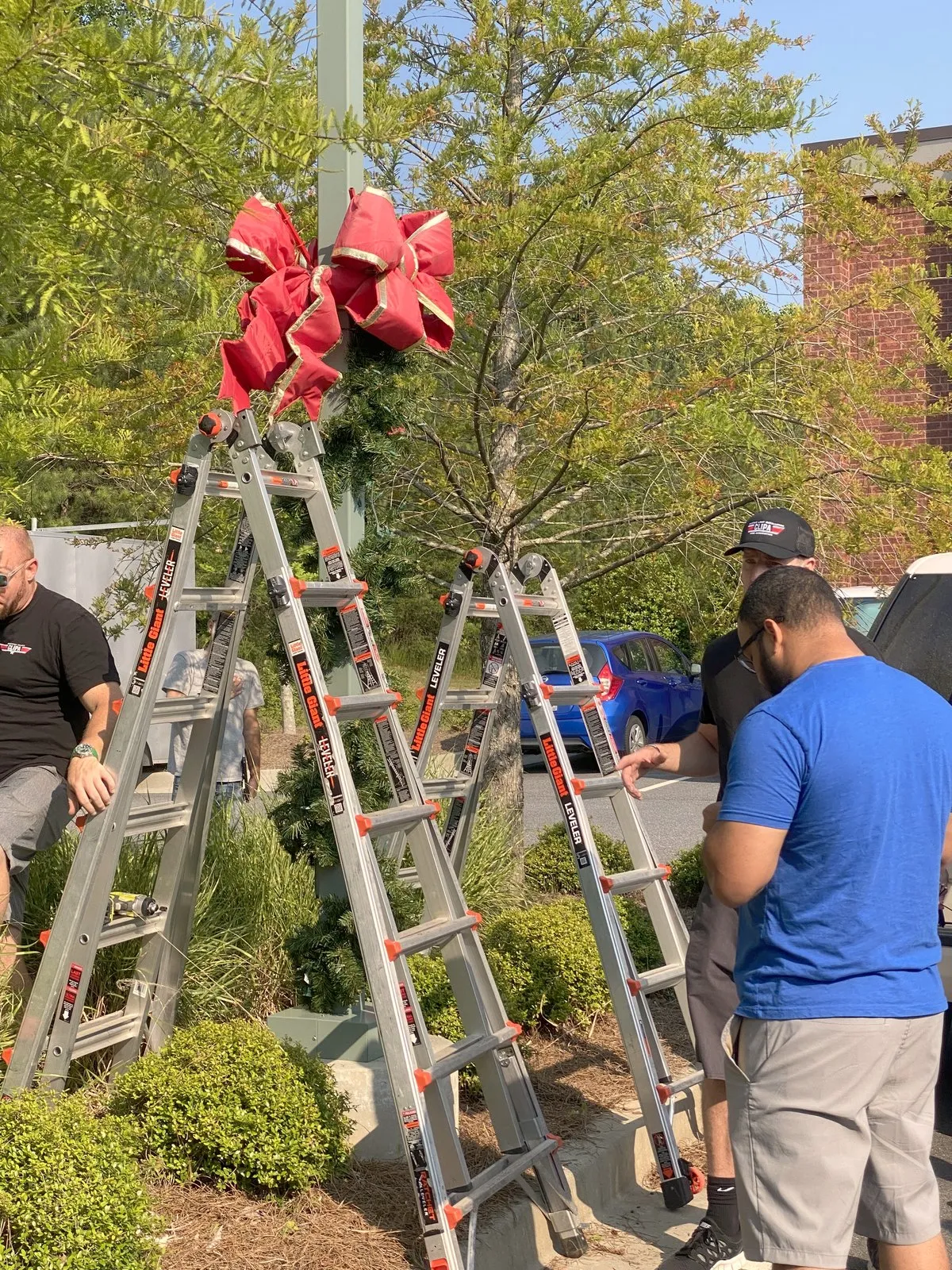 Setting oversized bows on street poles, installed by South Custom Lighting in North Texas