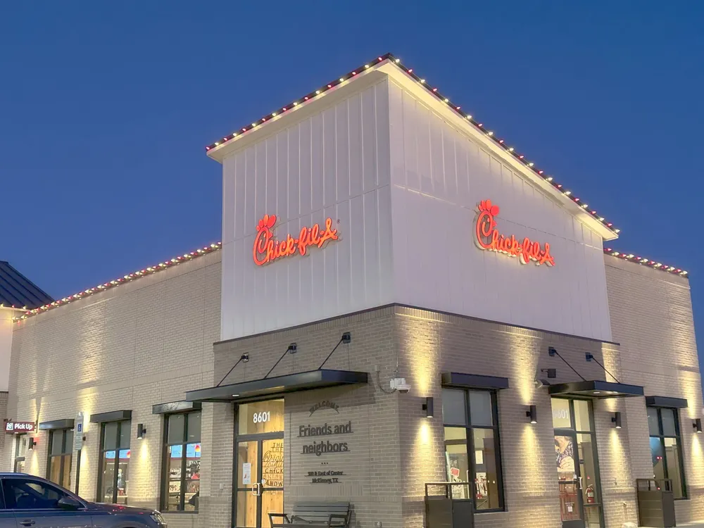 A commercial restaurant roofline lit at blue hour before evening traffic arrives