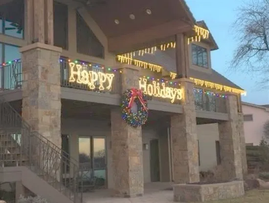 Custom Happy Holidays lettering with a lit wreath, installed by South Custom Lighting in North Texas