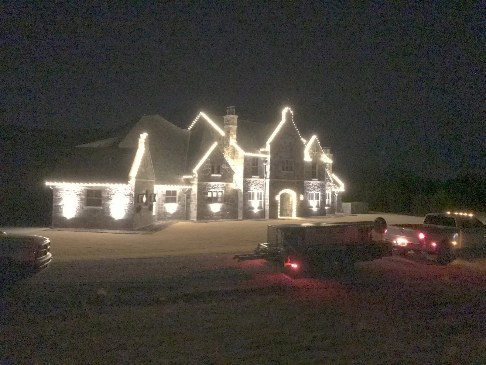 A North Texas home with multiple gables picked out in warm white Christmas lights