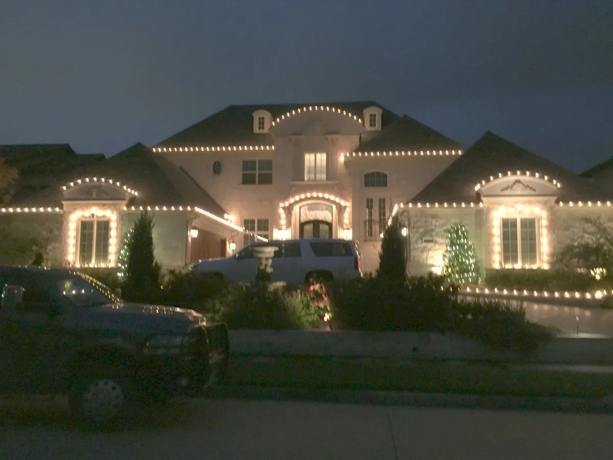 Stone home outlined on every peak and dormer, installed by South Custom Lighting in North Texas