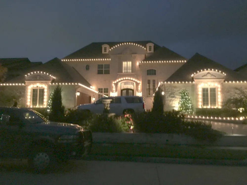 A finished warm white roofline install on a North Texas stone home